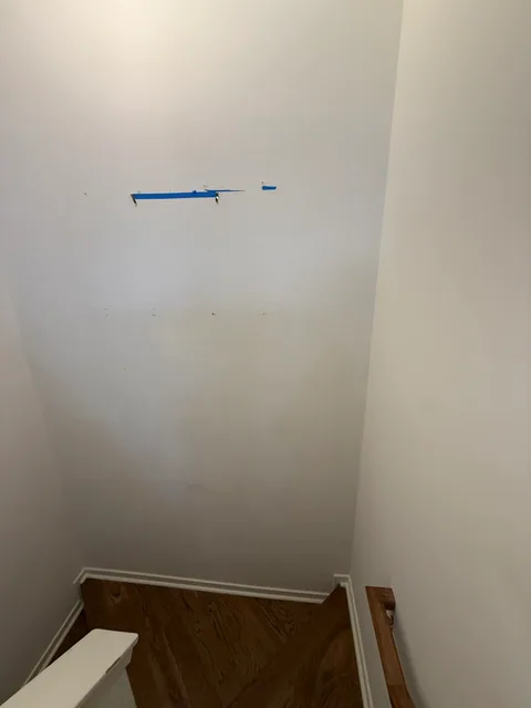 Stair wall with mounting holes before repair in South End