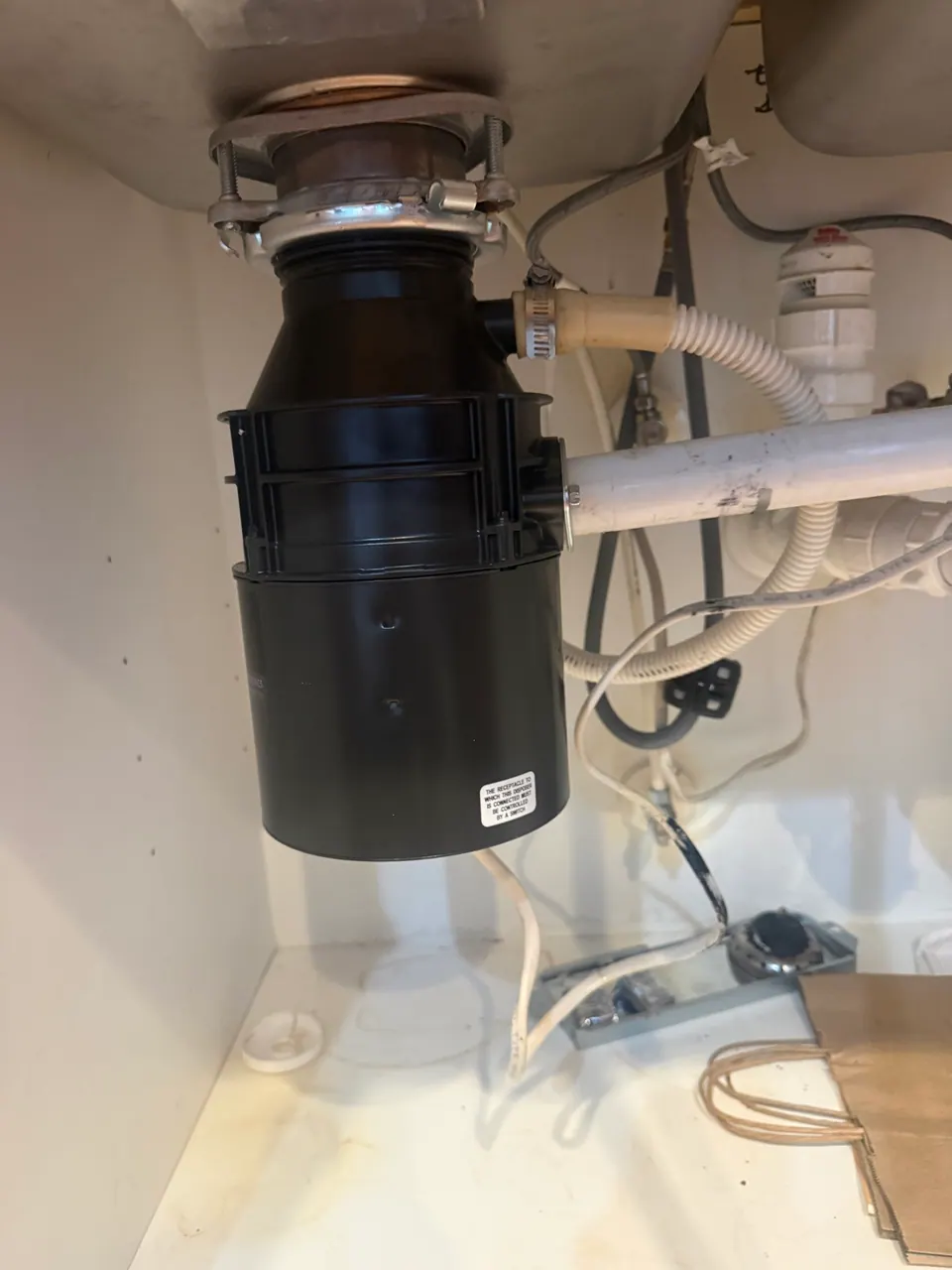 New garbage disposal installed under a kitchen sink by FixCraft VP in Charlotte NC