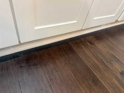 Close view of the restored flooring along the kitchen cabinets