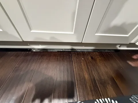 Close view of the cut-out floor section at the kitchen cabinet base